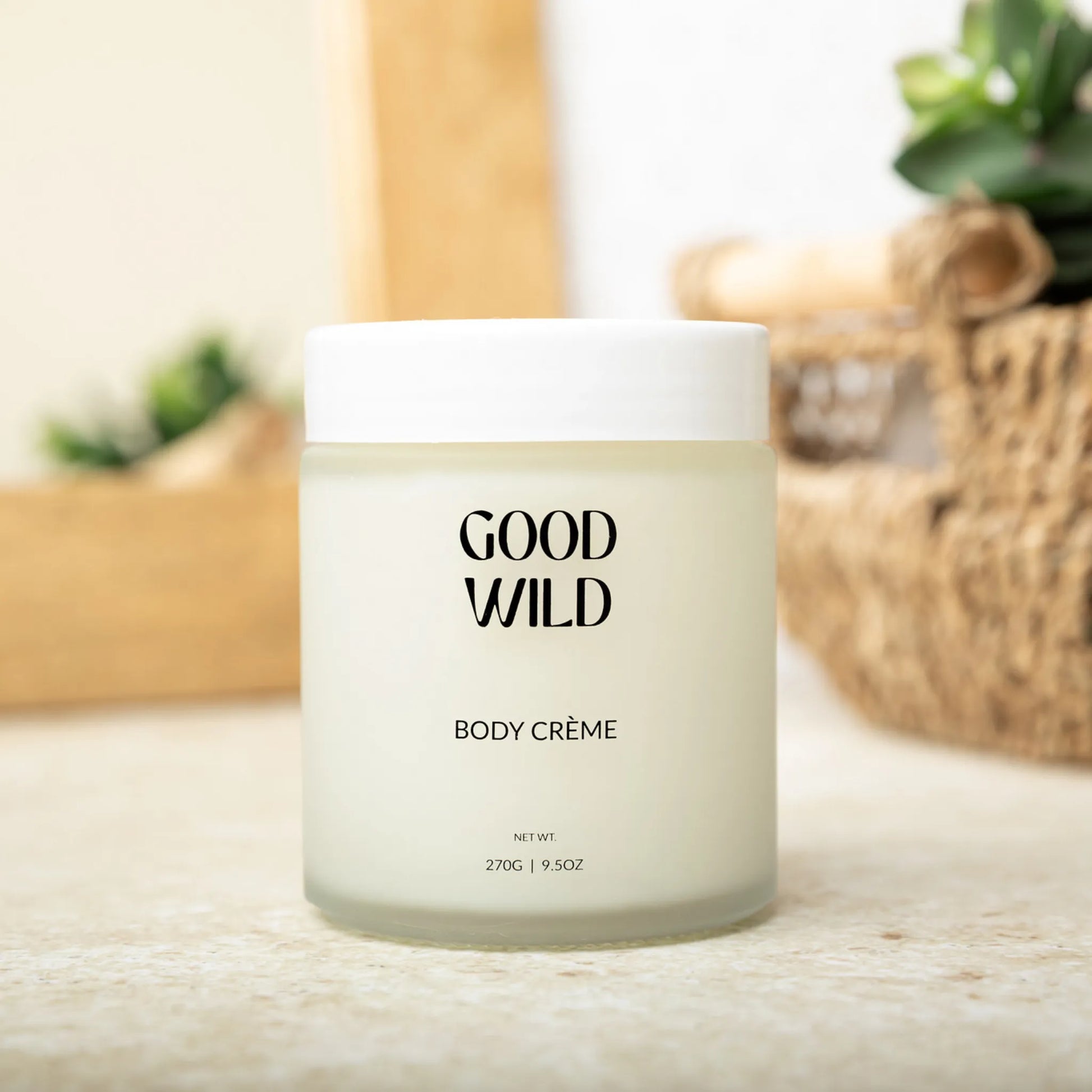 Jar of Good Wild body crème on a light wooden surface with blurred background