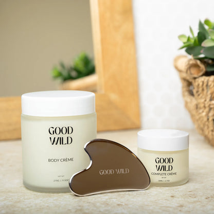 Two jars of 'Good Wild' body and complete crème with a tool on a wooden surface.