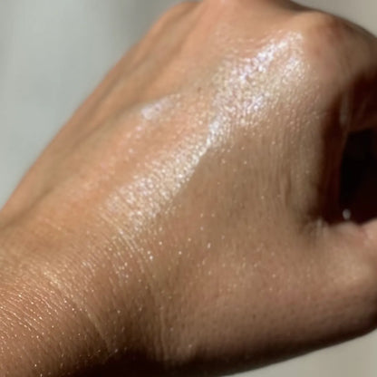Close-up of a hand with a light-colored cream applied to the wrist.
