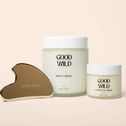 Two jars of 'Good Wild' body and complete crème with a gua sha tool on a beige background